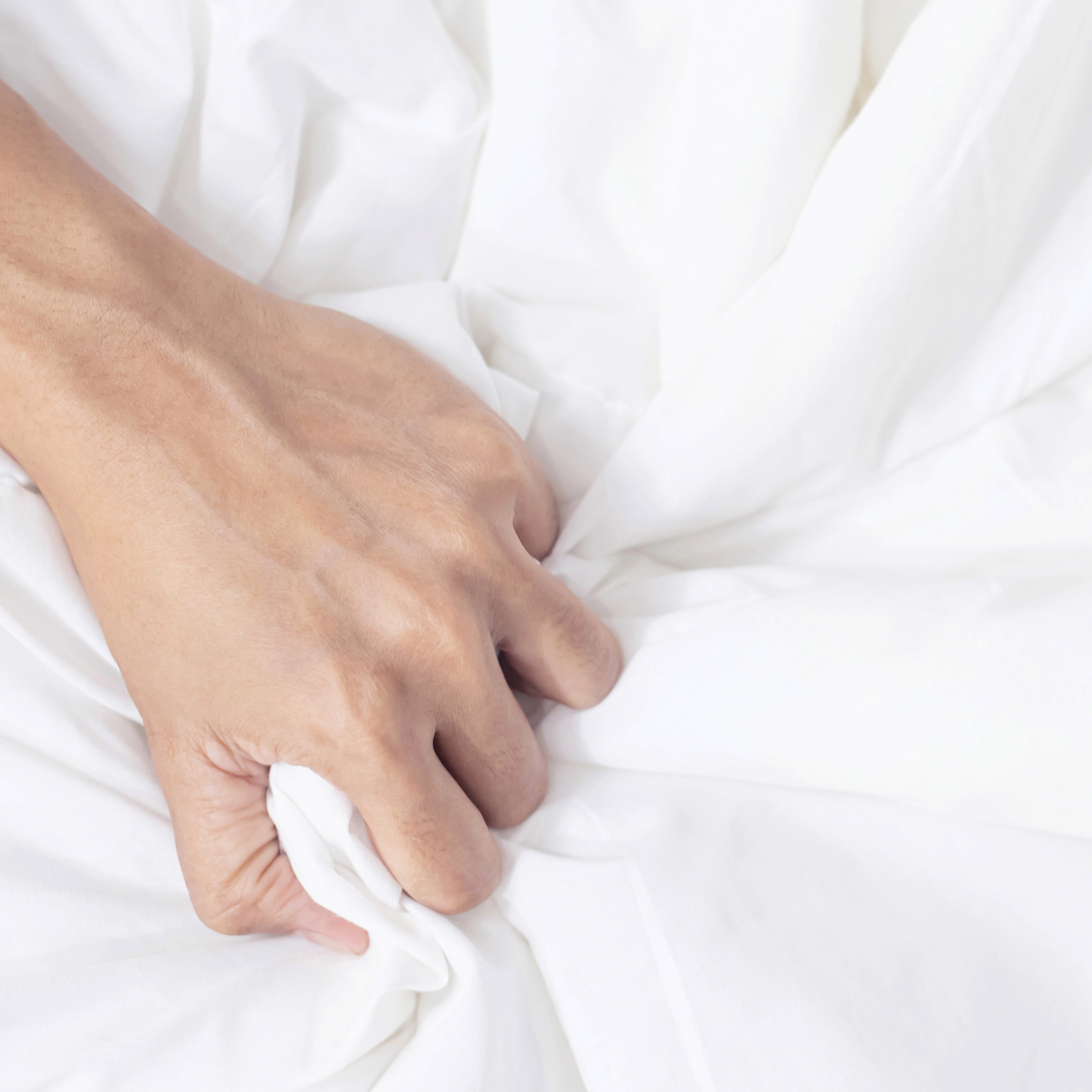 Hand holding white fabric against a white background