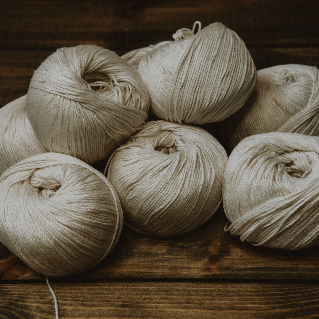 Beige yarn balls on a wooden surface