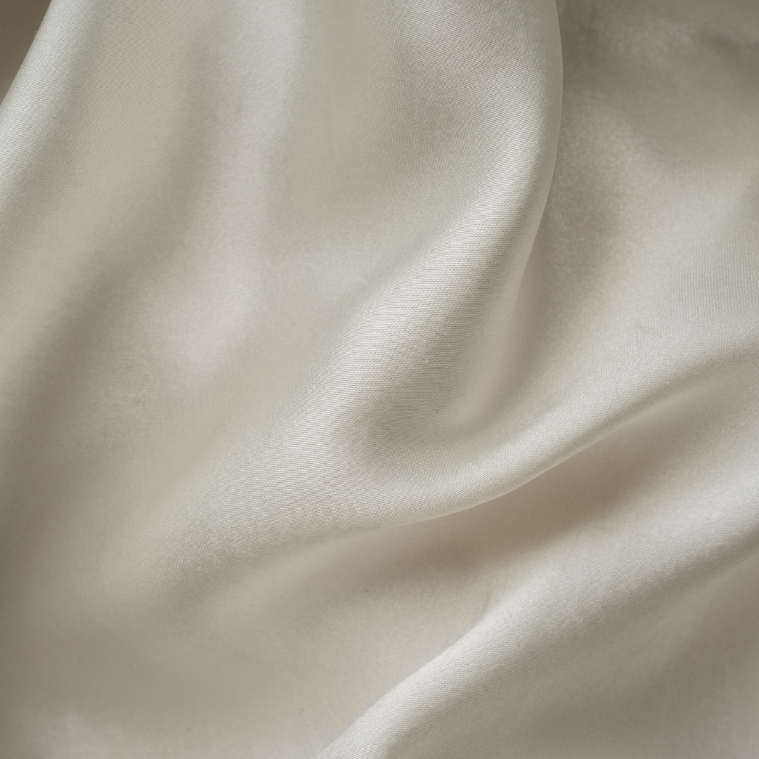 Trees and Hugs Organic Cotton Bed Sheets, luxurious ivory fabric close-up showcasing soft texture, sustainable and breathable weave for eco-conscious comfort and natural sleep experience