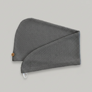 A Trees & hugs Gray textured hair wrap with a coconut shell button and white loop, folded neatly on a solid gray background.