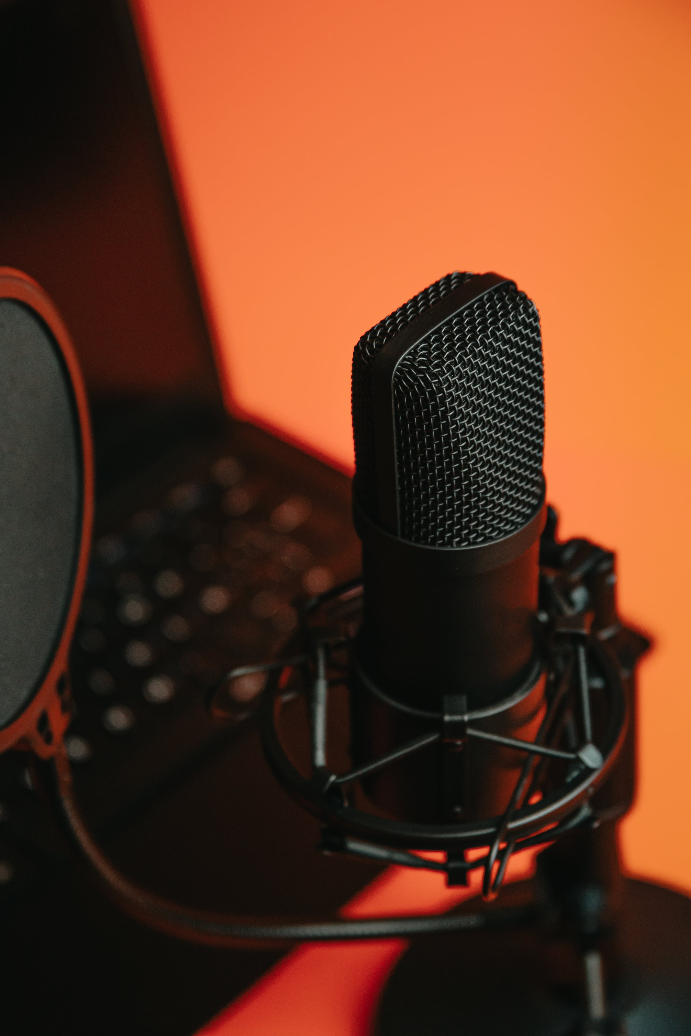 black-microphone-on-a-stand-reflecting-orange-light.jpg