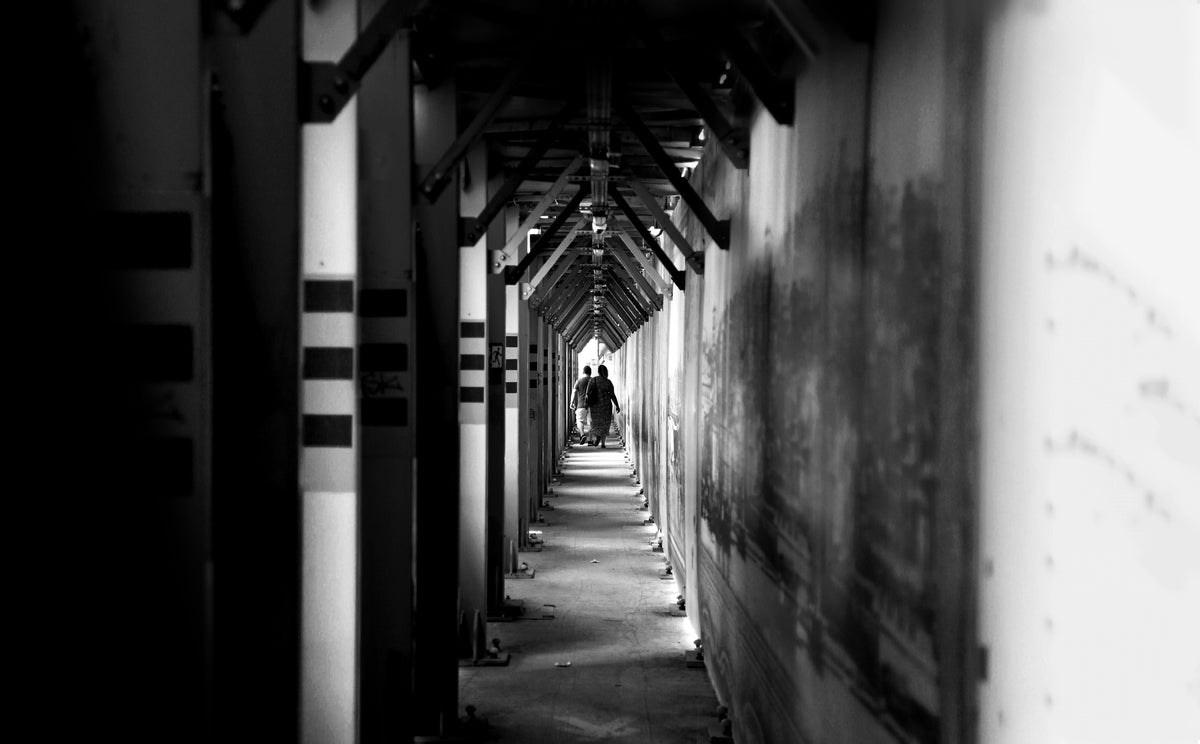 two-people-walk-down-a-long-hallway.jpg