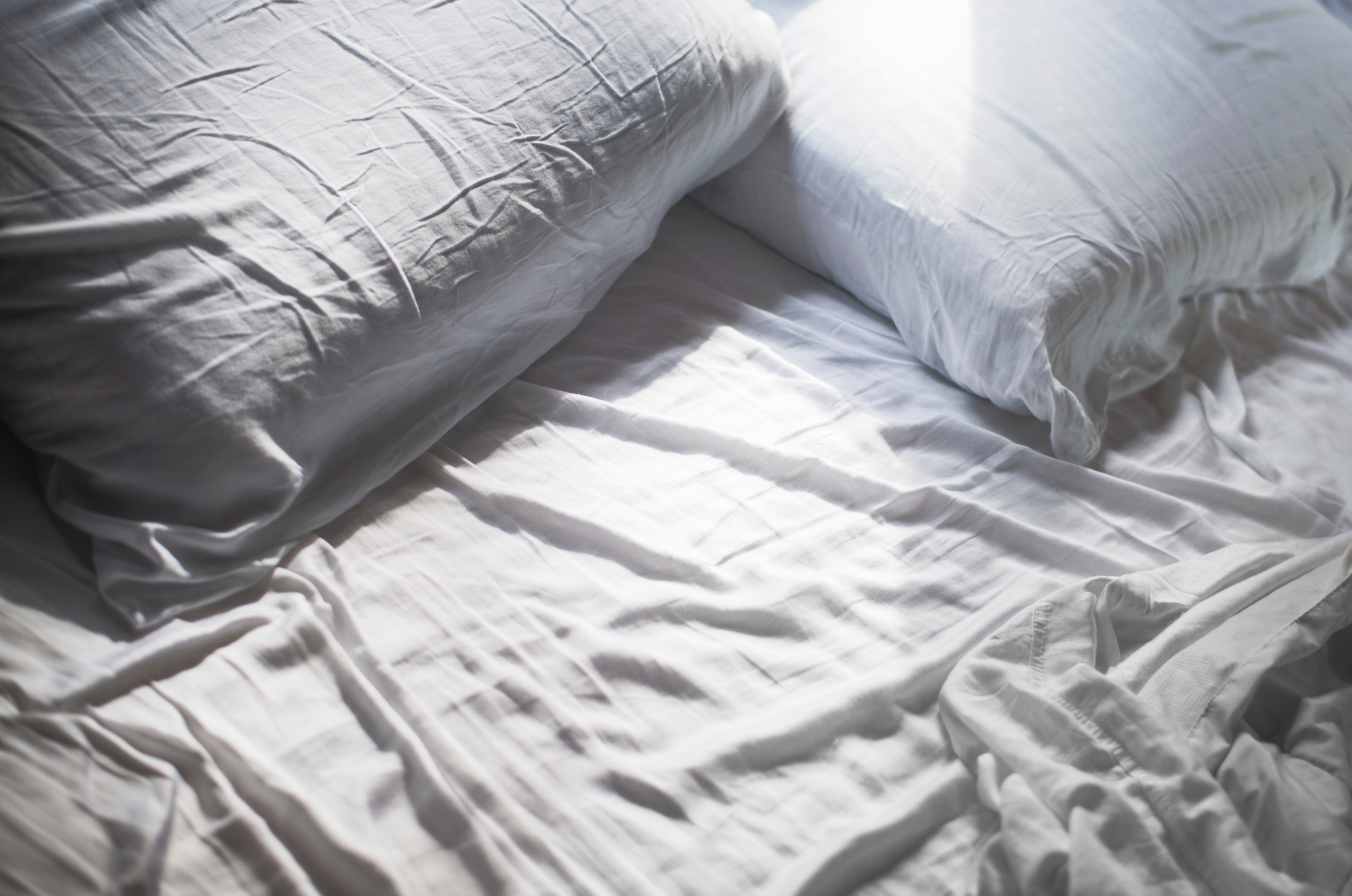 white-pillows-and-sheets-of-a-bed-unmade.jpg